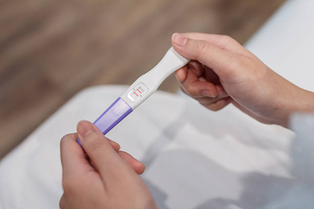 A woman holding a positive pregnancy test